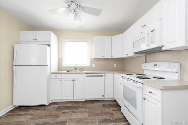 a kitchen with cabinets appliances a sink and a counter top space