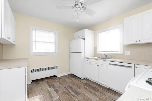 a kitchen with granite countertop a sink cabinets a window and stainless steel appliances