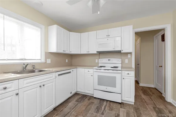 a kitchen with cabinets appliances a sink and a window
