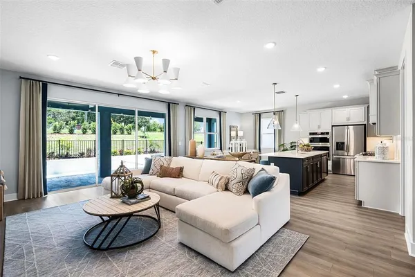 a living room with furniture kitchen and a large window