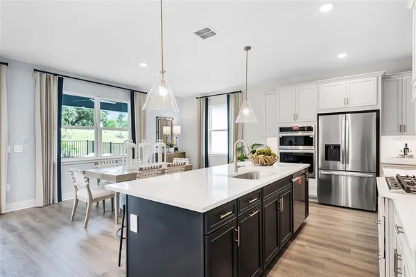a kitchen with a stove a refrigerator and a dining table