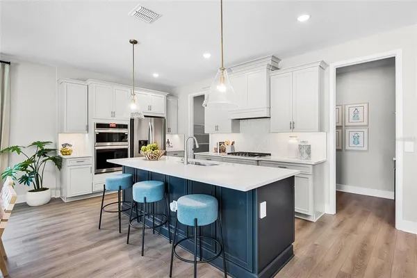 a kitchen with a island a sink stainless steel appliances and cabinets