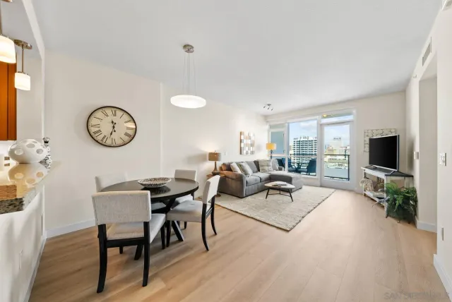 a living room with furniture a clock and a flat screen tv