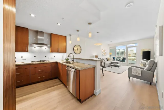 a large kitchen with stainless steel appliances a stove a sink dishwasher and a fireplace with wooden floor