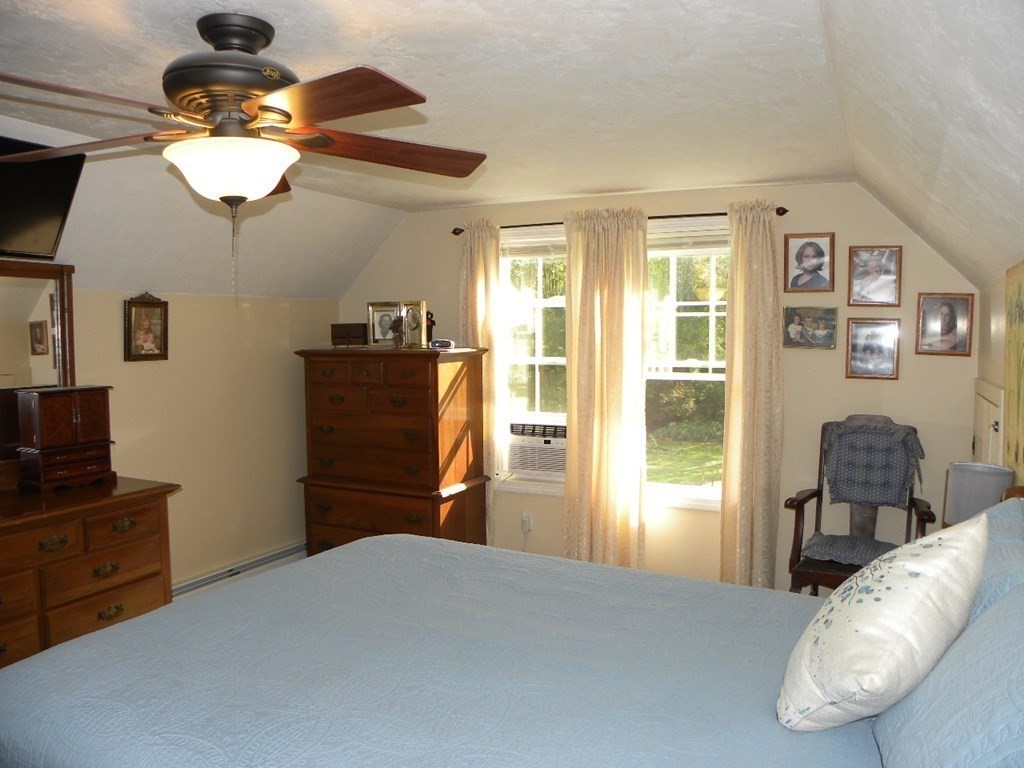 360 Coldbrook Road Oakham, MA 01068 - Photo 12 of 28 a bedroom with a bed and a chandelier