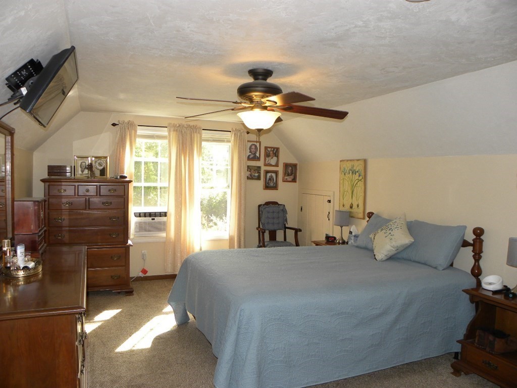 360 Coldbrook Road Oakham, MA 01068 - Photo 13 of 28 a bedroom with a bed and a chandelier