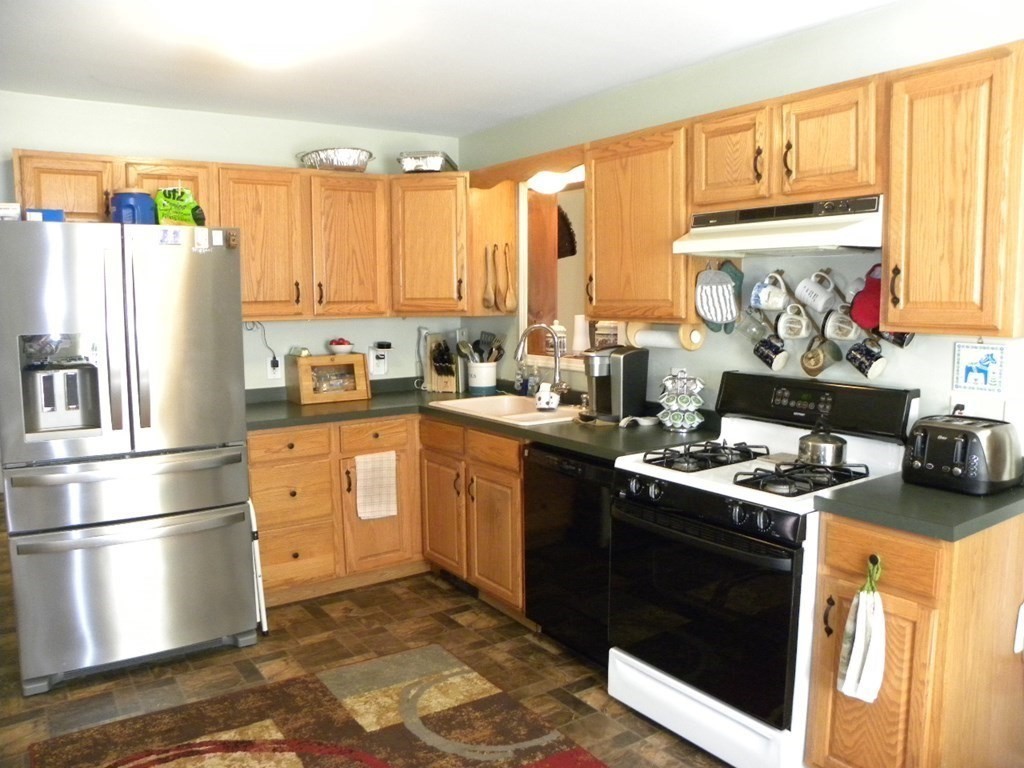 360 Coldbrook Road Oakham, MA 01068 - Photo 14 of 28 a kitchen with stainless steel appliances a stove sink refrigerator and cabinets