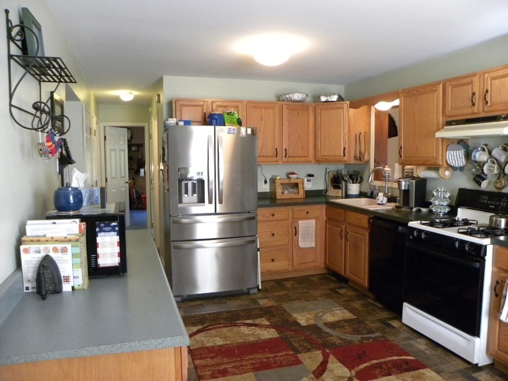 360 Coldbrook Road Oakham, MA 01068 - Photo 17 of 28 a kitchen with kitchen island a counter top space a sink stainless steel appliances and cabinets