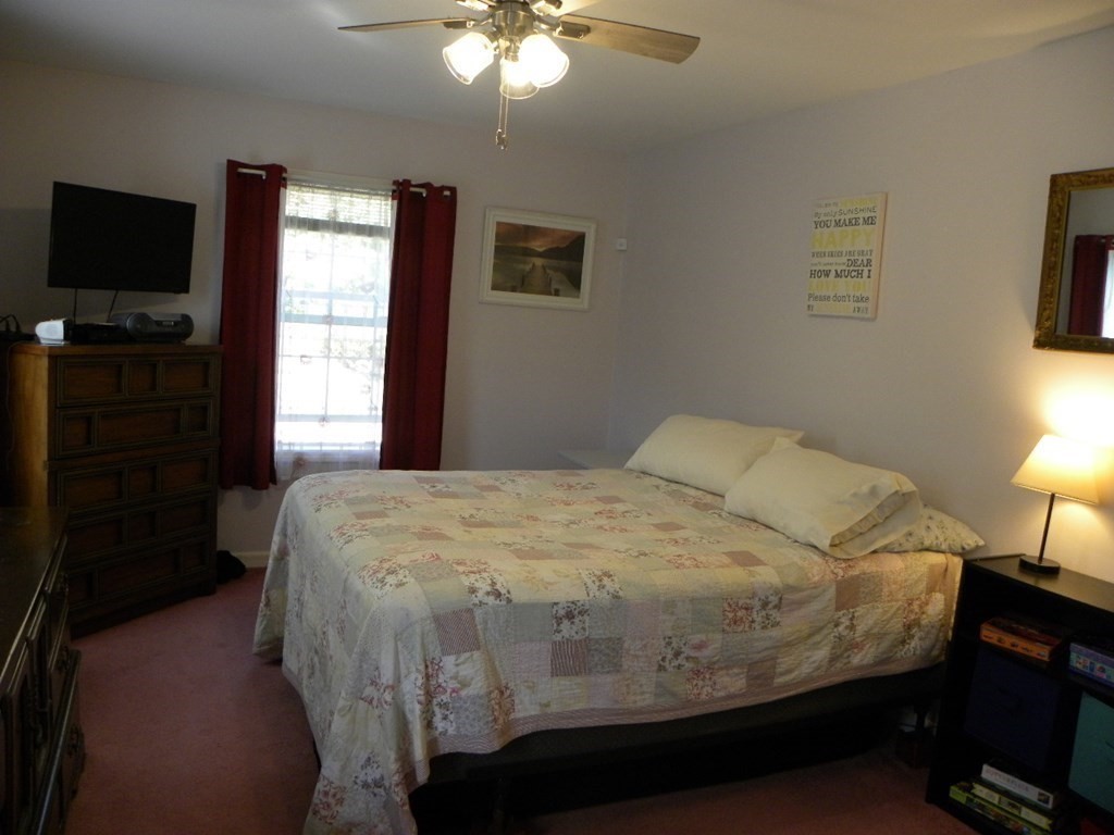 360 Coldbrook Road Oakham, MA 01068 - Photo 23 of 28 a bedroom with a bed and a flat tv screen on dresser