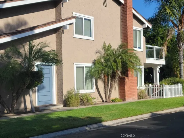 a front view of a house with a yard and trees