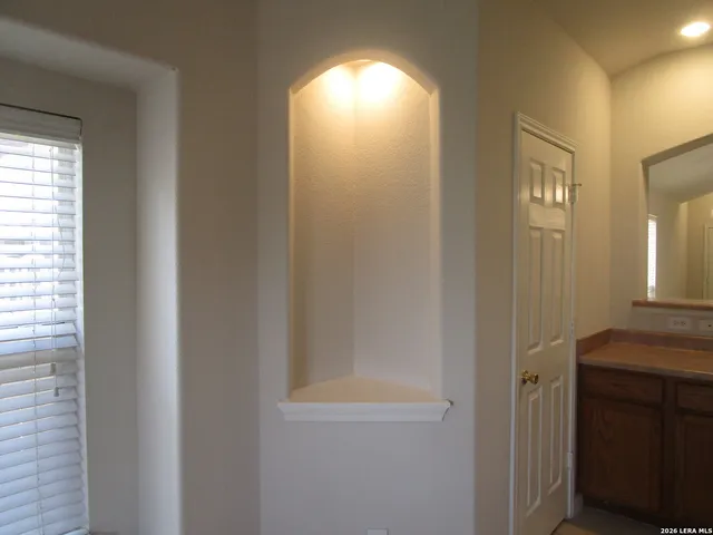 a view of a room with a ceiling fan and window