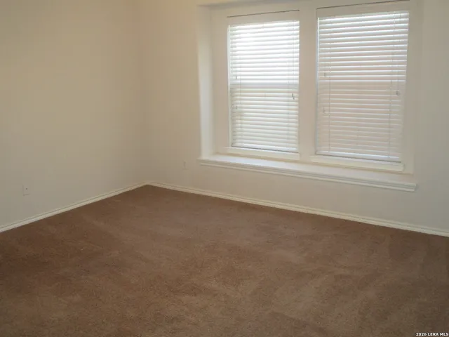 a view of a room with wooden floor and a window