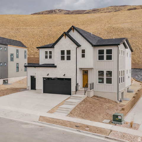 Modern inspired farmhouse featuring board and batten siding, driveway, and a garage