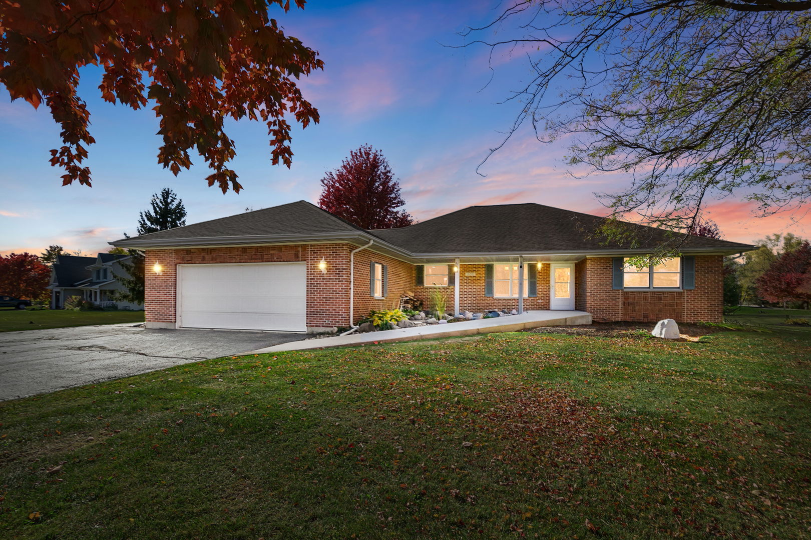 a front view of a house with a garden and tree