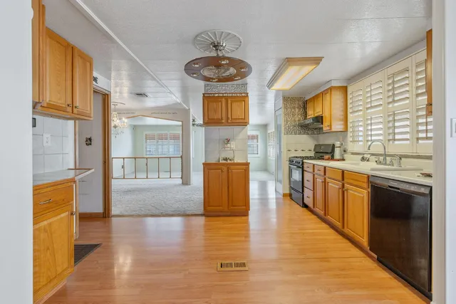 a large kitchen with stainless steel appliances granite countertop a stove and a large window
