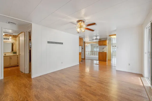 a view of empty room with wooden floor and window