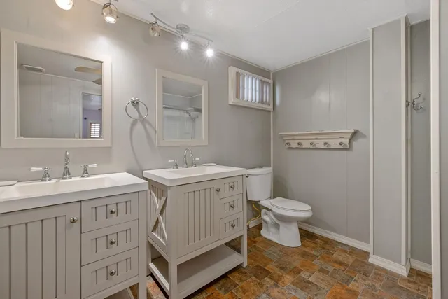 a bathroom with a toilet a sink and a mirror