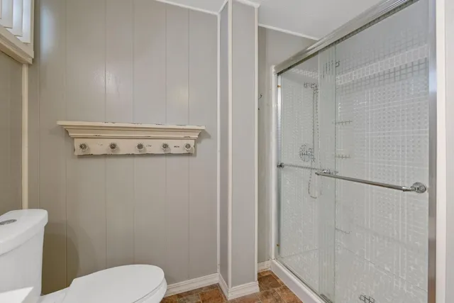 a bathroom with a toilet and a shower