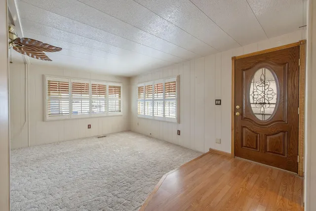 a view of an empty room with a window and dresser