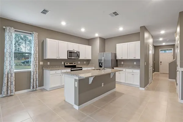 a kitchen with granite countertop a stove microwave and sink