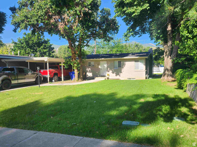 545 100 East Bountiful, UT 84010 - Photo 1 of 17 Ranch-style house featuring a front lawn, an attached carport, brick siding, and a chimney