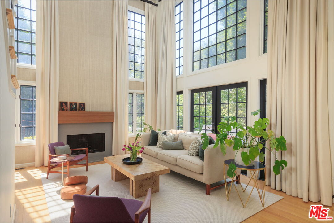 a living room with furniture fireplace and potted plants