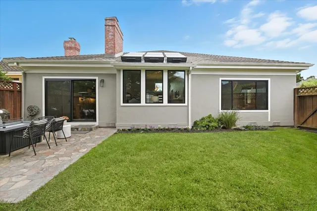a view of a house with backyard sitting area and garden