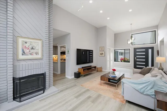 a living room with furniture a flat screen tv and a fireplace