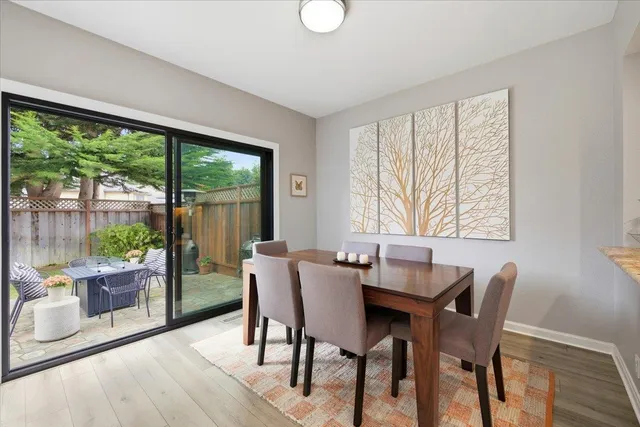 a dining room with furniture a chandelier and wooden floor