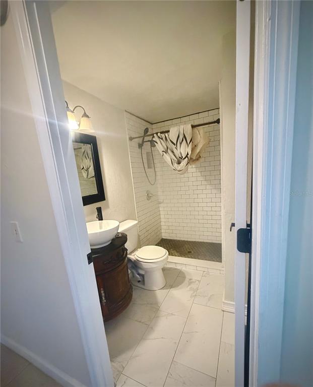 375 Pine Woods Road Ormond Beach, FL 32174 - Photo 9 of 16 a bathroom with a granite countertop toilet a sink and a shower