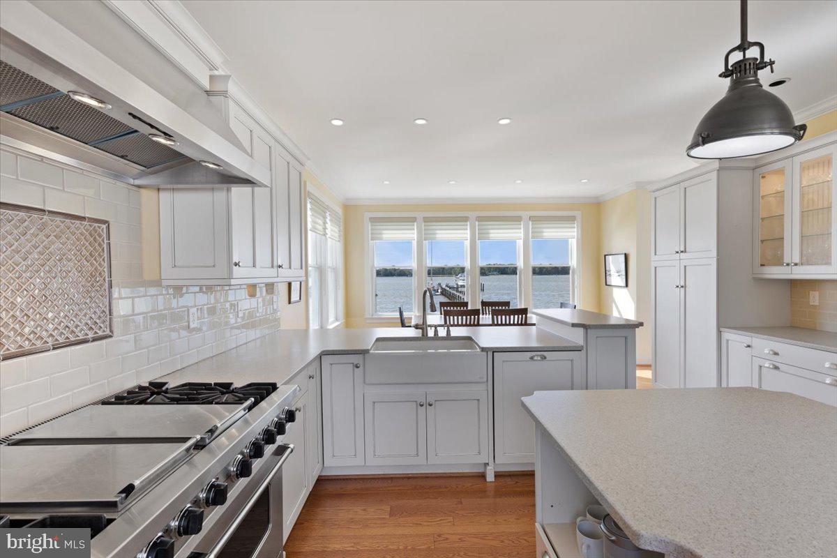 1100 Steamboat Road Shady Side, MD 20764 - Photo 16 of 81 a kitchen with a stove a sink dishwasher a refrigerator and white cabinets with wooden floor