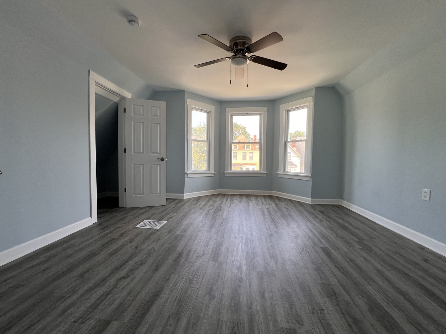 6528 South Sangamon Street Chicago, IL 60621 - Photo 5 of 14 an empty room with wooden floor and windows