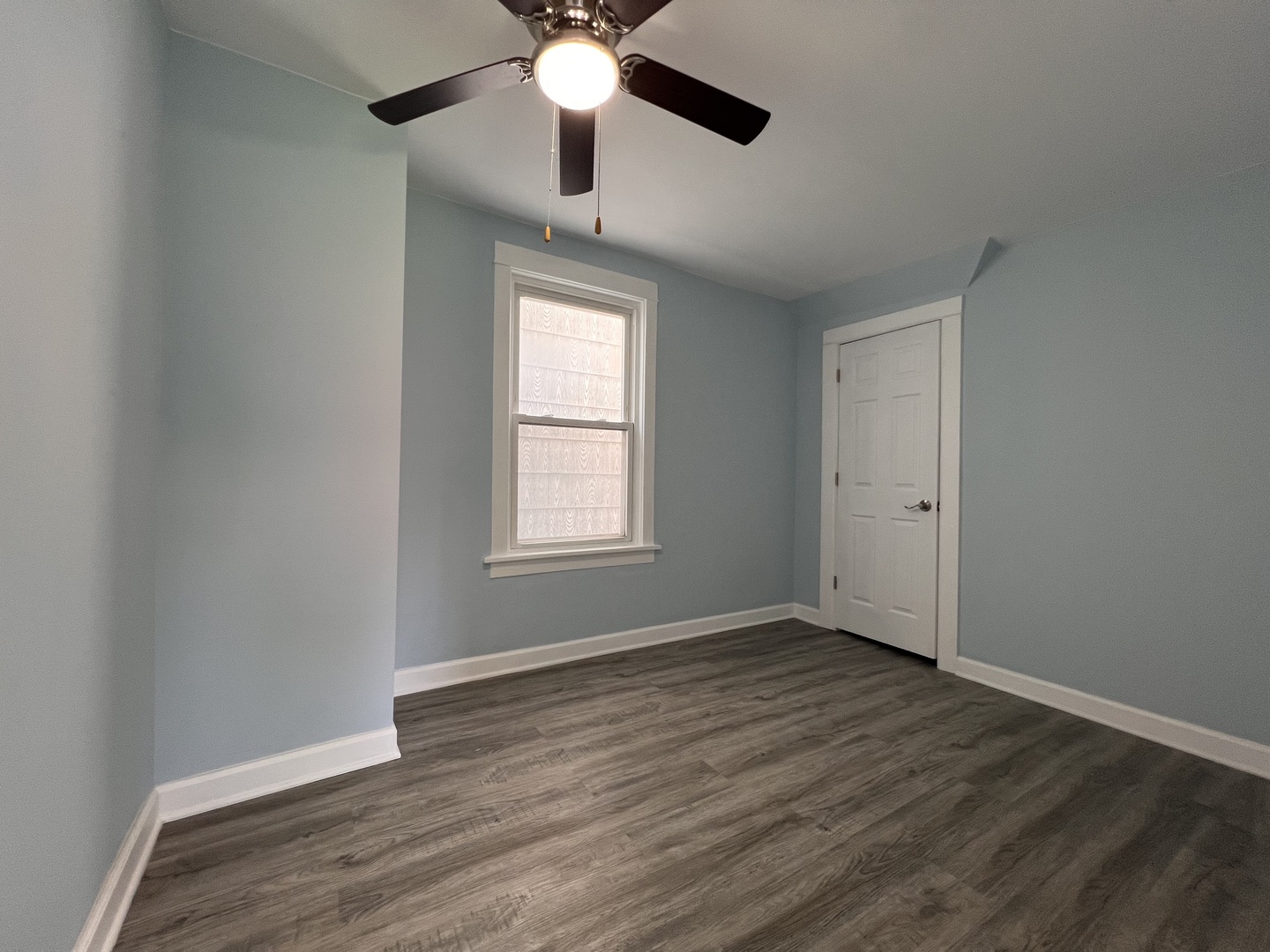 6528 South Sangamon Street Chicago, IL 60621 - Photo 6 of 14 an empty room with wooden floor fan and windows