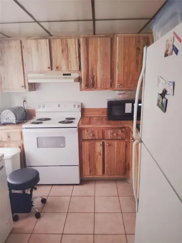 a kitchen with a stove top oven and cabinets