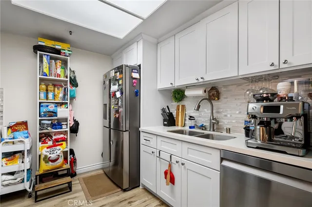 a kitchen with stainless steel appliances granite countertop a refrigerator and cabinets