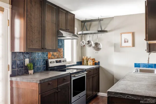 a kitchen with stainless steel appliances granite countertop a stove a sink and a refrigerator