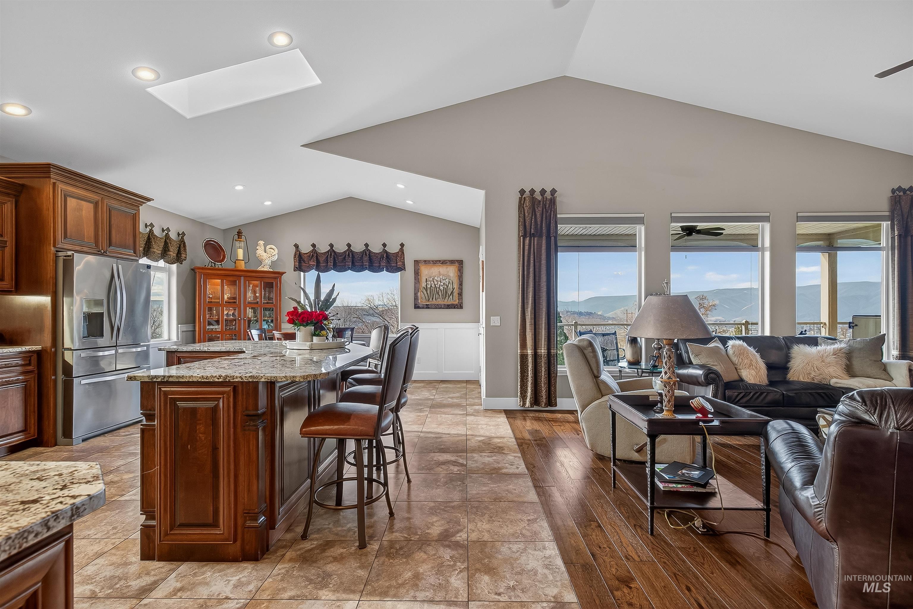 3978 Foothill Drive Lewiston, ID 83501 - Photo 12 of 40 Kitchen with stainless steel refrigerator with ice dispenser, a breakfast bar area, light stone countertops, a skylight, and lofted ceiling