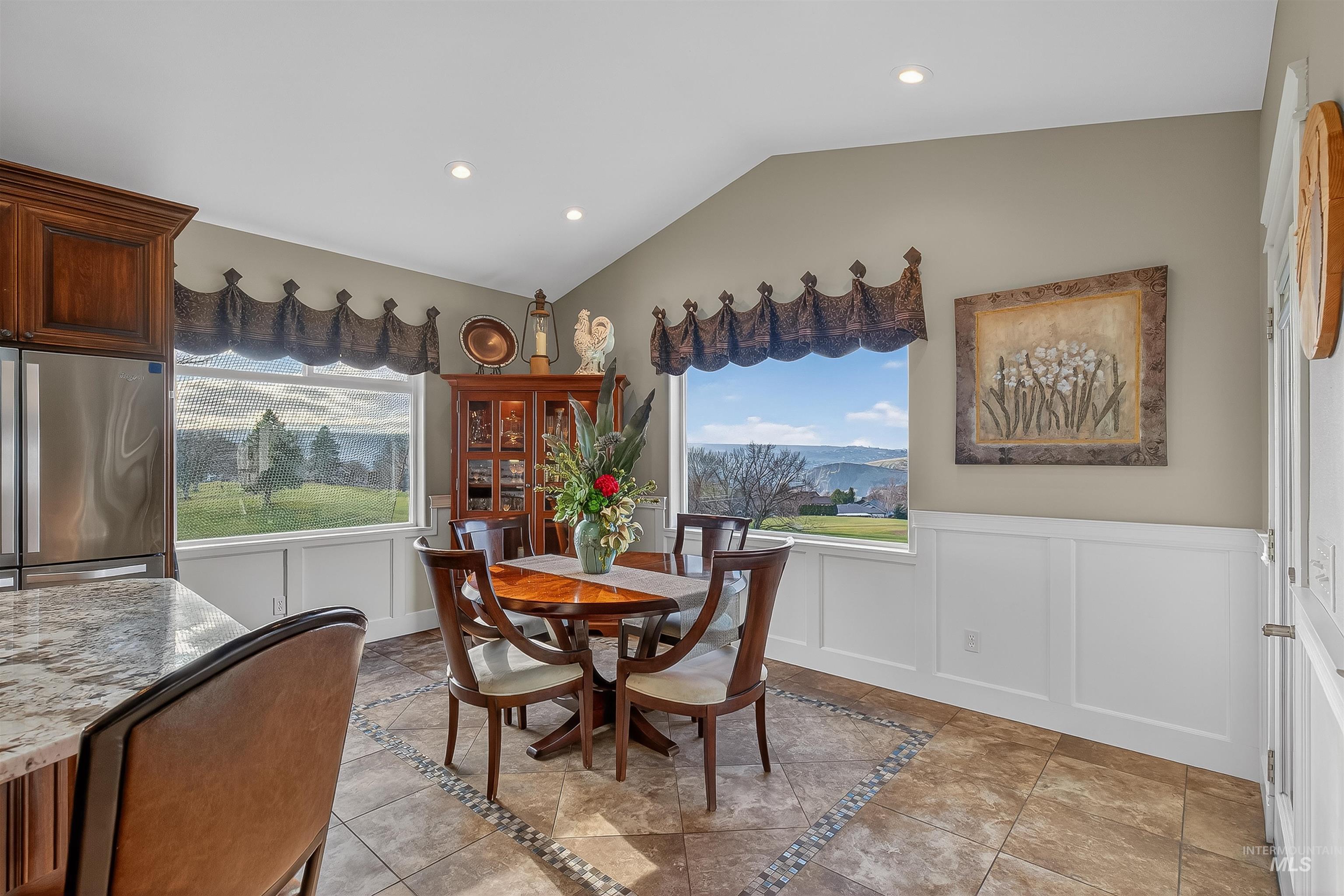 3978 Foothill Drive Lewiston, ID 83501 - Photo 17 of 40 Dining space with a decorative wall, wainscoting, vaulted ceiling, healthy amount of natural light, and inlaid floor details