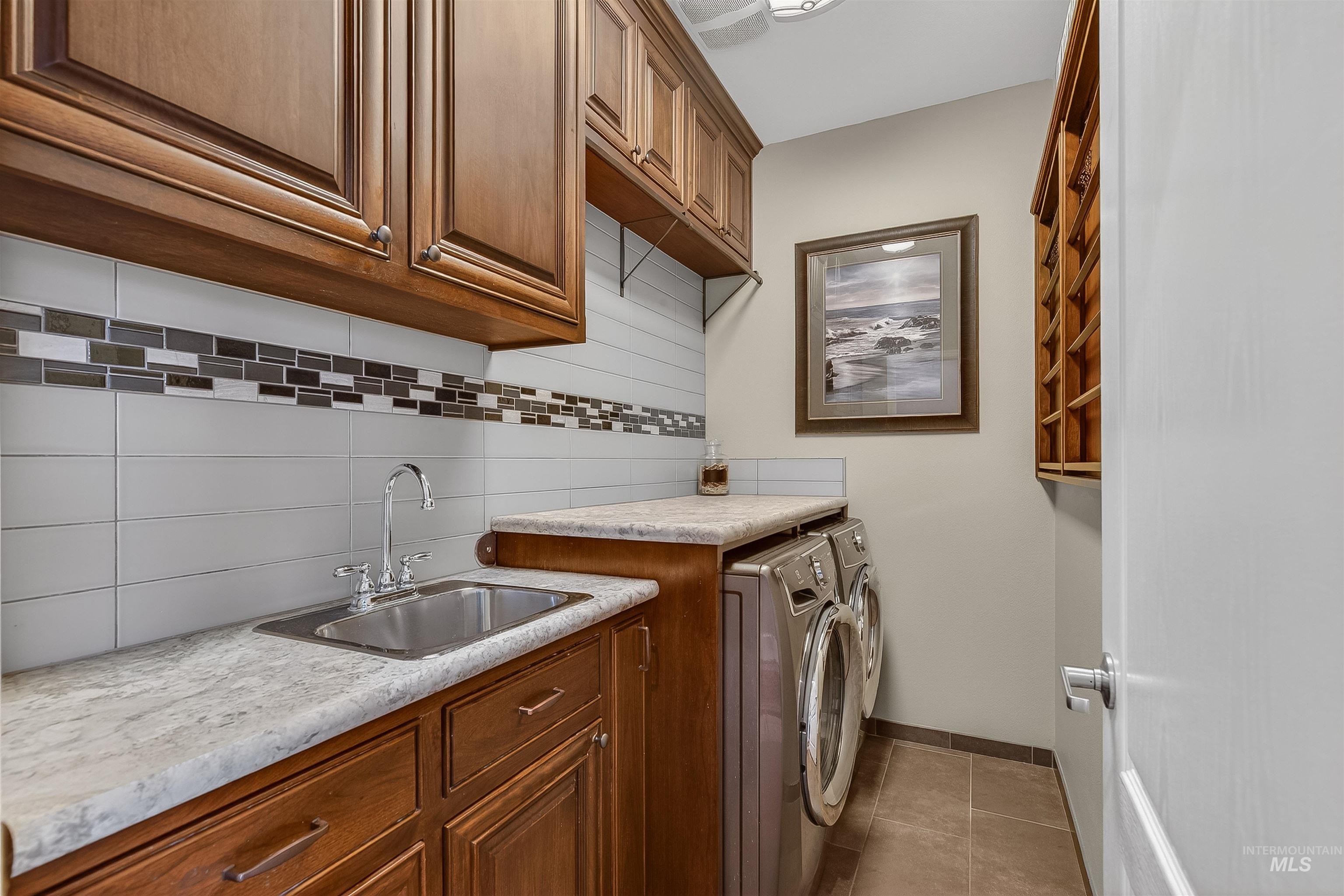3978 Foothill Drive Lewiston, ID 83501 - Photo 18 of 40 Washroom featuring washer and clothes dryer, cabinet space, and dark tile patterned flooring