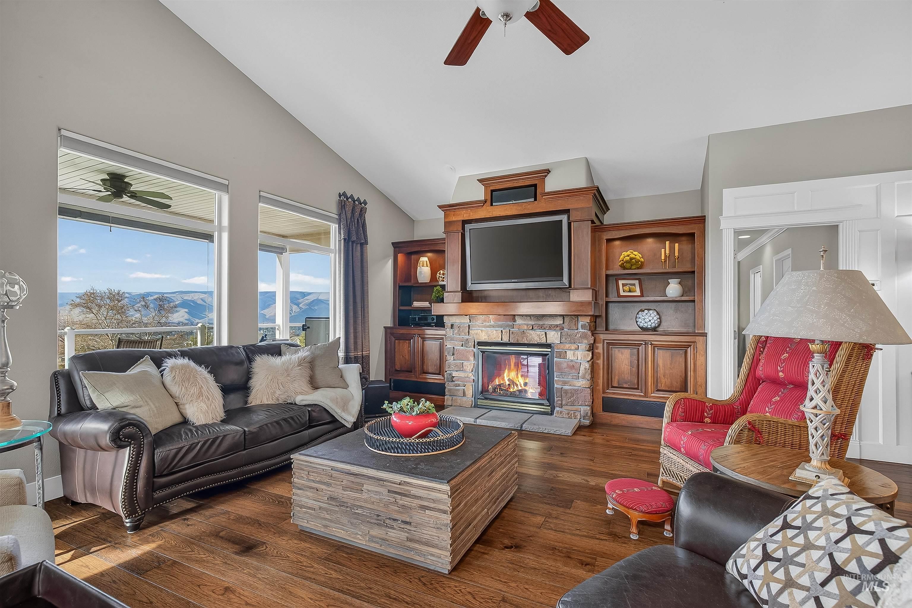 3978 Foothill Drive Lewiston, ID 83501 - Photo 9 of 40 Living room with ceiling fan, dark wood finished floors, vaulted ceiling, and a stone fireplace