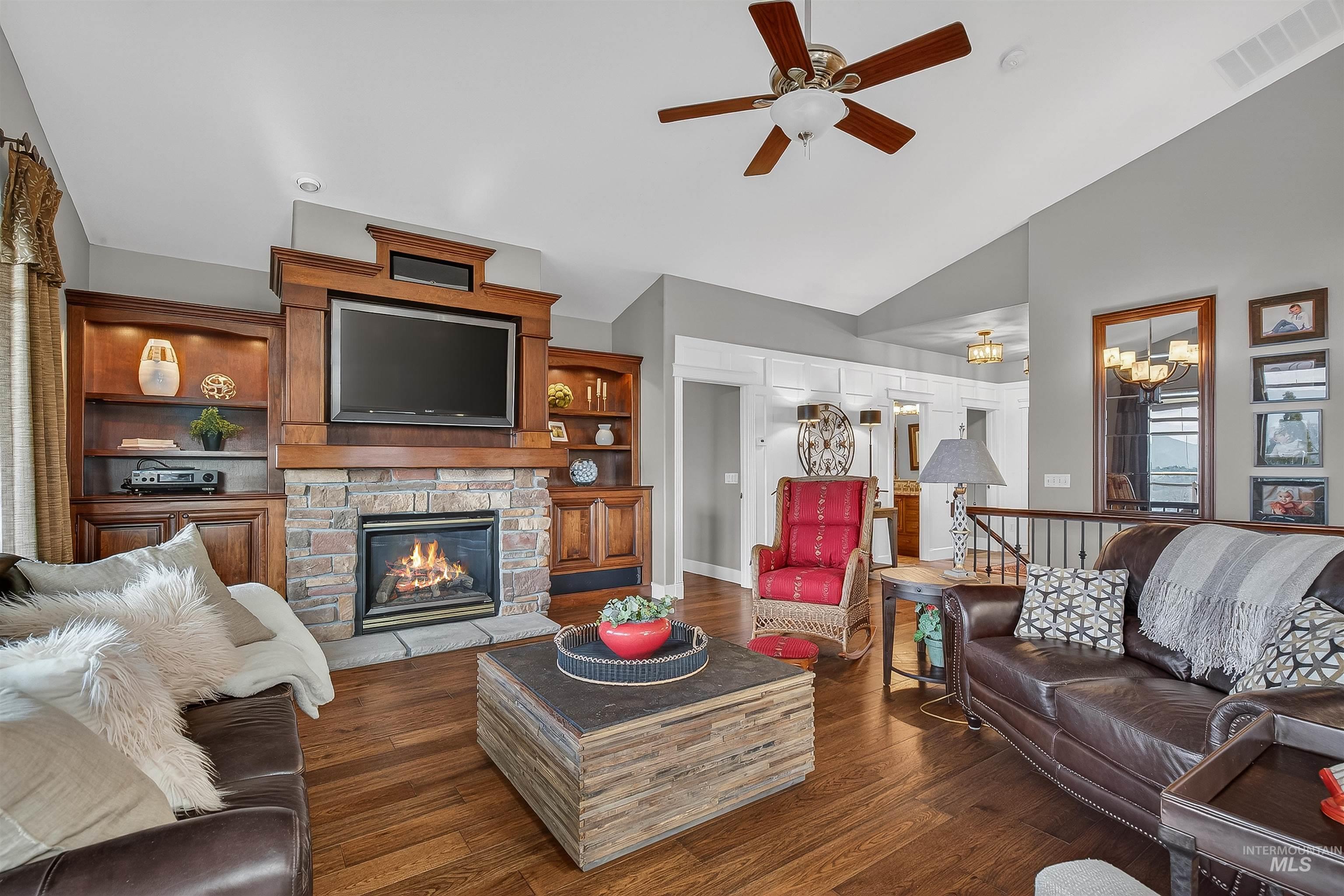 3978 Foothill Drive Lewiston, ID 83501 - Photo 10 of 40 Living room featuring dark wood-type flooring, a fireplace, a chandelier, high vaulted ceiling, and ceiling fan