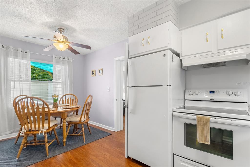 5596 100th Way North St. Petersburg, FL 33708 - Photo 16 of 67 a kitchen with stainless steel appliances granite countertop a dining table chairs and a refrigerator