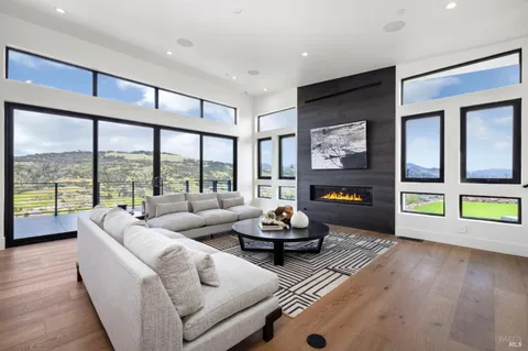a living room with furniture and a large window with balcony view