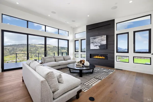 a living room with furniture and a large window with balcony view