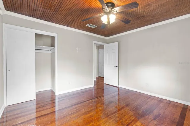 a view of empty room with wooden floor