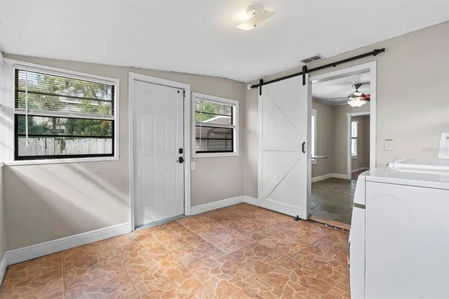 a view of empty room with window and refrigerator
