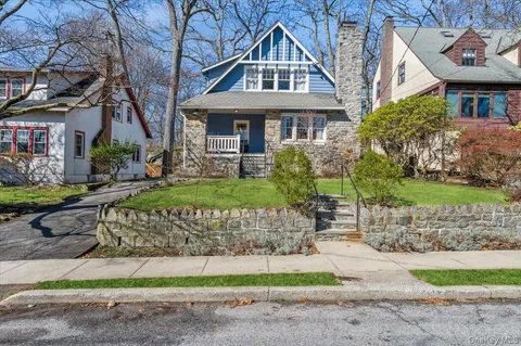 a front view of a house with a garden and plants