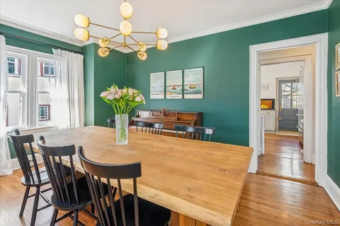 a dining room with furniture potted plants and wooden floor