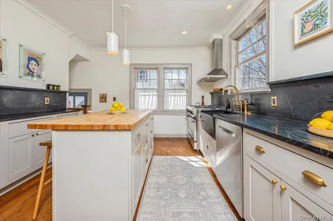 a kitchen with stainless steel appliances a sink stove and cabinets