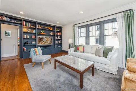 a living room with furniture and a book shelf